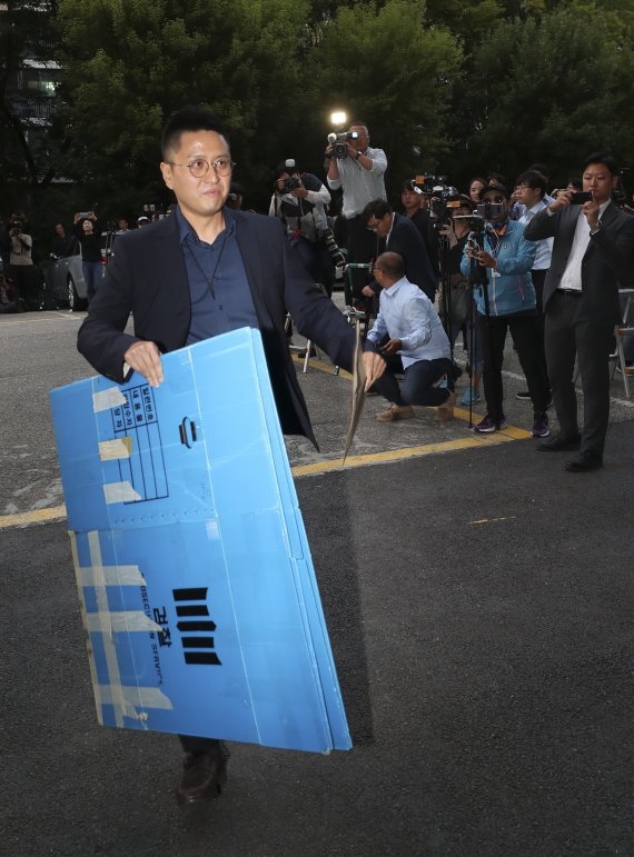 검찰 수사관이 23일 오후 서울 방배동 조국 법무부 장관 자택 압수수색을 하기 위해 상자를 들고 아파트 현관으로 들어가고 있다. 사진=서동일 기자
