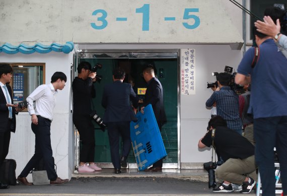 검찰 수사관이 23일 오후 서울 방배동 조국 법무부 장관 자택 압수수색을 하기 위해 상자를 들고 아파트 현관으로 들어가고 있다. 사진=서동일 기자