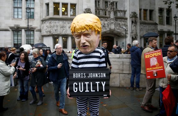 영국 런던의 대법원 앞에서 24일(현지시간) 보리스 존슨 총리에 반대하는 시위대가 "보리스 존슨 유죄"라는 팻말을 들고 서 있다.로이터뉴스1