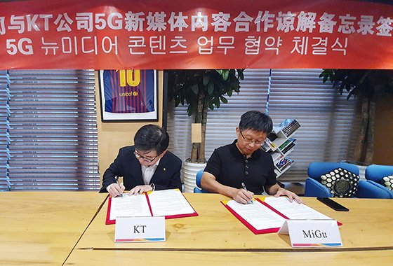 김훈배 KT 뉴미디어사업단 단장(왼쪽)과 류신 차이나모바일 미구 대표가 협약서에 서명하고 있다. KT 제공