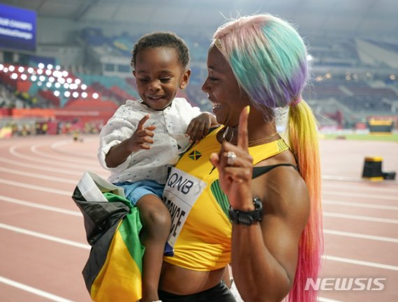 【도하=AP/뉴시스】셸리 앤 프레이저-프라이스(자메이카)가 29일(현지시간) 카타르 도하 칼리파 스타디움에서 열린 2019 도하 세계육상선수권대회 여자 100ｍ 결선에서 우승 후 아들 지온을 안고 기뻐하고 있다. 출산 후 복귀한 프레이저 프라이스(33)는 10초 71로 우승해 2015년 베이징 대회 이후 4년 만에 세계선수권 여자 100ｍ 우승을 차지했다. 2019.09.30.