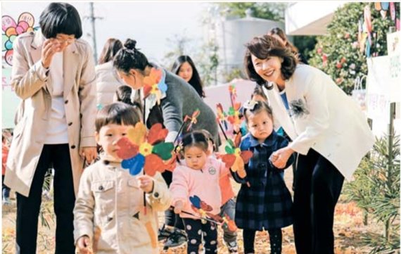 이어룡 회장(오른쪽 첫번째)이 영유아 보육시설인 이화영아원 앞 뜰에서 아이들과 반갑게 인사하고 기념 사진을 찍고 있다.