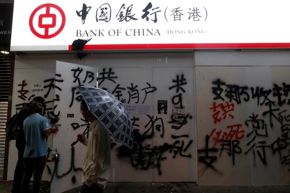 People stand in front of graffiti-covered wall of Bank of China branch during an anti-government rally in Mong Kok district, Hong Kong, China October 6, 2019. REUTERS/Jorge Silva /REUTERS/뉴스1 /사진=