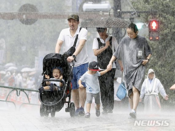 【도쿄=AP/뉴시스】지난 9월9일 폭우가 내리는 도쿄에서 한 가족이 비를 맞으며 걷고 있다. 2019.09.09.
