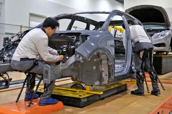 현대자동차 직원이 의자형 착용로봇을 착용하고 작업하는 모습(현대차 제공)© News1