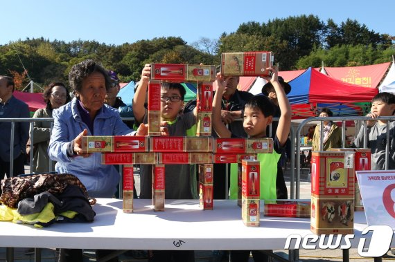 전북 진안군 마이산 북부 일원에서 진안홍삼축제가 열리고 있는 가운데 한 관광객이 홍삼캔 쌓기를 하고 있다. /뉴스1