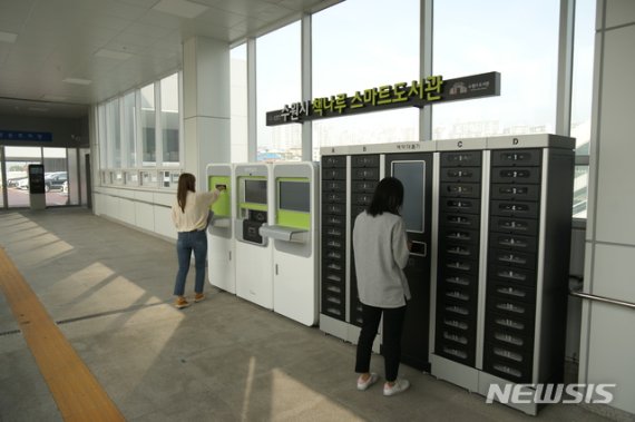 【수원=뉴시스】김경호 기자= 경기 수원 성균관대역에 설치된 스마트도서관을 시민들이 이용하고 있는 모습.