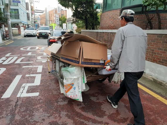 8일 오전 서울 강서구에서 이모씨(68)가 주택가에서 수거한 폐지를 운반하고 있다/사진=이진혁 기자