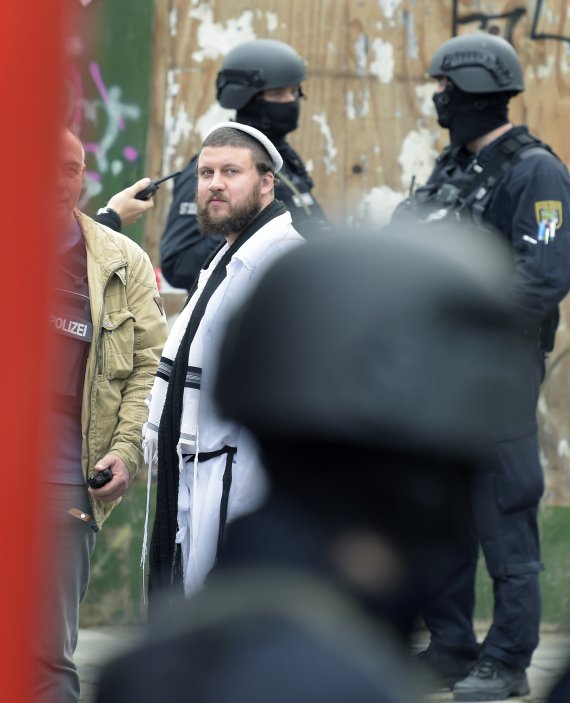 독일 동부 할레에서 9일(현지시간) 전통 유대교 복식을 입은 주민이 유대교 회당 인근에서 경찰들을 지켜보고 있다.AP뉴시스