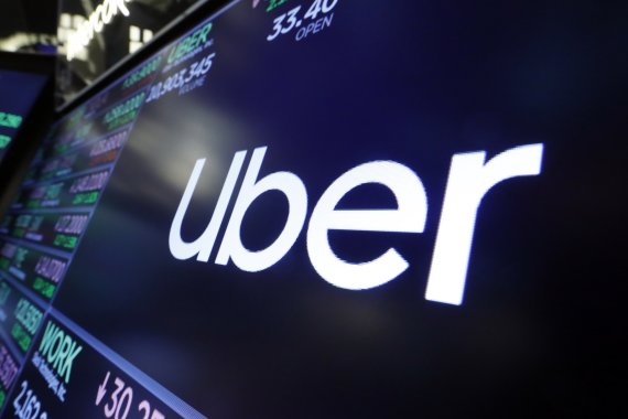 FILE - In this Friday, Aug. 16, 2019 file photo, the logo for Uber appears above a trading post on the floor of the New York Stock Exchange. (AP Photo/Richard Drew, file) /뉴시스/AP /사진=
