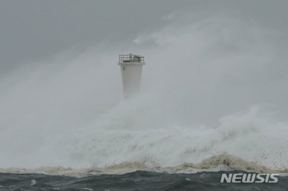 12일 일본 미에(三重)현 기호(紀寶)항에서 19호 태풍 하기비스로 인해 생긴 파도가 방파제와 등대를 덮치고 있다./사진=뉴시스