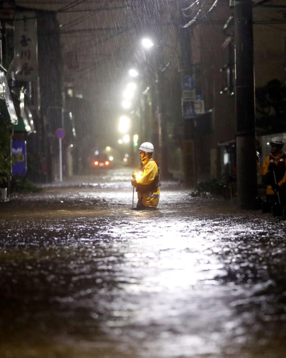 12일 일본 도쿄 오타구. 소방대원이 태풍으로 침수된 도로를 순찰하고 있다. 로이터 뉴스1