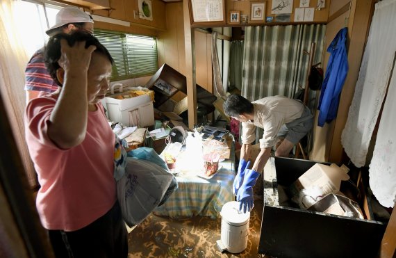 13일 도쿄 인근 가와사키시 주민들이 태풍 하기비스로 인해 침수된 가옥을 청소하고 있다. AP뉴시스