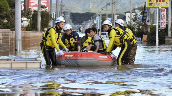 13일 후쿠시마 이와키지역에서 주민들이 침수된 도로 위에 띄워진 구명보트를 통해 이동하고 있다. 로이터 뉴스1
