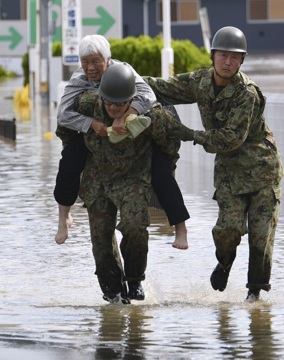 13일 일본 자위대가 후쿠시마 지역 모토미야 지역에서 태풍으로 고립된 한 주민을 구조하고 있다. AP뉴시스