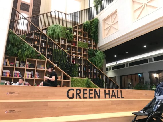 롯데몰 수지점 4층 '그린홀'에서 고객들이 배치된 책을 읽으며 시간을 보내고 있다. 사진=김서원 인턴기자