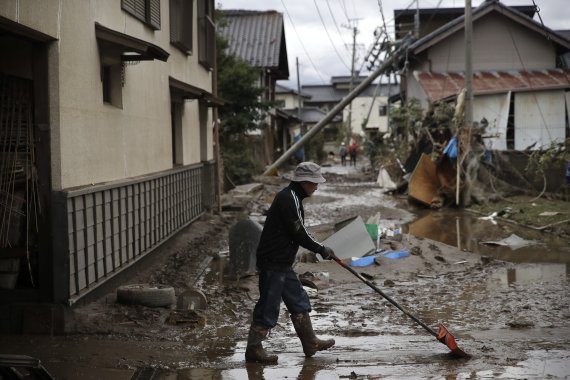지난 15일 일본 나가노 지역에서 한 남성이 19호 태풍 하기비스로 인해 진흙탕이 된 도로를 복구하고 있다. AP뉴시스