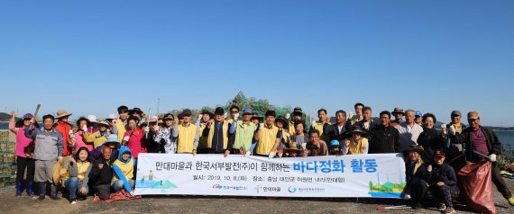 한국서부발전 직원들과 지역주민들이 '만대 한마음 만선제'의 성공적인 개최를 위해 지난 8일 바다환경 정화활동을 실시하고 기념촬영을 하고 있다. 한국서부발전 제공
