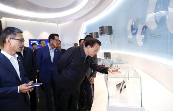 리커창 중국 총리(오른쪽 첫번째)가 지난 14일 중국 산시성 시안에 위치한 삼성전자 반도체 공장을 방문해 전시된 제품을 살펴보고 있다.뉴스1