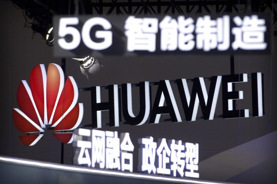 FILE - In this Sept. 26, 2018, file photo, signs promoting 5G wireless technology from Chinese technology firm Huawei are displayed at the PT Expo in Beijing. The Federal Network Agency in Germany issued rules Tuesday Oct. 15, 2019, releasing draft security guidelines for next generation 5G wireless