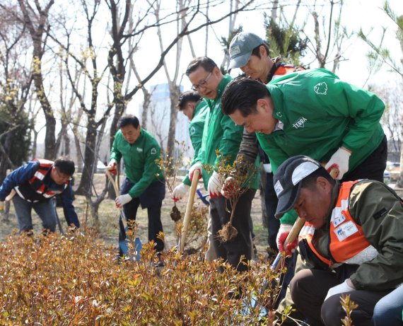 하이트진로 김인규 대표(오른쪽 두번째)와 협력사 임직원들이 지난 4월 아름다운숲 조성 프로젝트에 동참해 나무를 심고 있다. 하이트진로 제공
