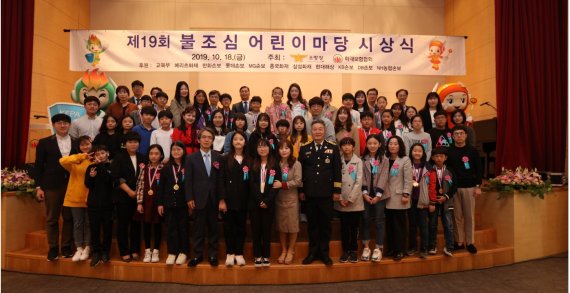 한국화재보험협회는 18일 서울 여의도에서 '제19회 불조심 어린이 마당' 시상식을 개최했다. '불조심 어린이 마당'은 어린이들이 화재 등 재난 및 생활안전에 관한 기초지식을 익혀 보다 안전하게 생활할 수 있도록, 화재보험협회가 전국의 초등학교 5학년 학생을 대상으로 실시하는 조기 안전교육 행사이다. 화재협회와 소방청 관계자들이 수상자들과 기념촬영을 하고 있다.