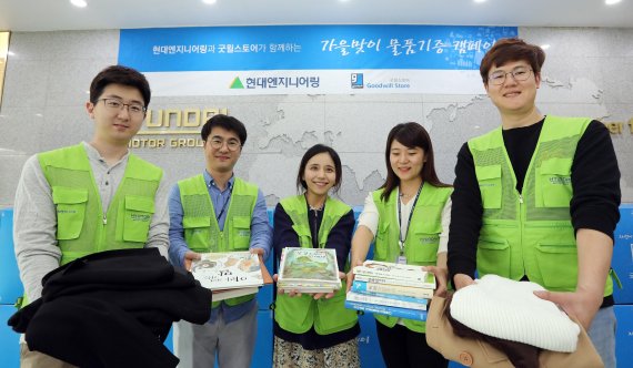 18일 서울 계동 현대엔지니어링 본사에서 진행된 ‘가을맞이 물품기증 캠페인’ 물품 전달식에서 현대엔지니어링 임직원들이 옷, 도서 등 각자 기증한 다양한 물품들을 들어 보이고 있다.