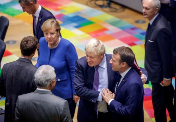 EU-英, 브렉시트 초안 합의 벨기에 브뤼셀에서 17일(현지시간) 열린 유럽연합(EU) 정상회의에 앙겔라 메르켈 독일 총리와 에마뉘엘 마크롱 프랑스 대통령 사이에 선 보리스 존슨 영국 총리(오른쪽 세번째)가 마크롱 대통령과 손을 맞잡고 다른 참석자들과 대화하고 있다. 로이터·뉴스1