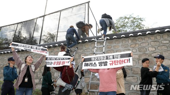 한국대학생진보연합 소속 대학생이 지난 18일 오후 서울 중구 주한 미국대사관저에서 방위비분담금 협상 관련 기습 농성을 하기 위해 담벼락을 넘고 있다.사진=뉴시스