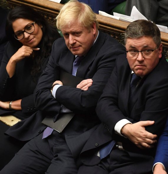 Britain's Prime Minister Boris Johnson, center, sits on the government front bench in the House of Commons in London following the debate for the EU Withdrawal Agreement Bill, Tuesday Oct. 22, 2019. British lawmakers have rejected the government?셲 fast-track attempt to pass its Brexit bill within da