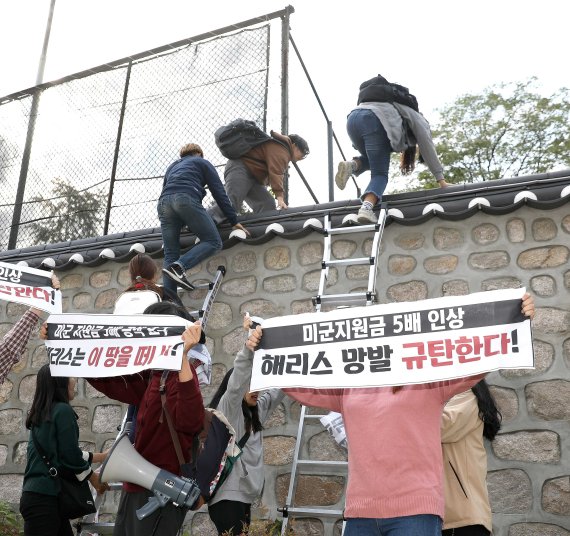한국대학생진보연합 소속 대학생이 지난 18일 오후 서울 중구 주한 미국대사관저에서 방위비분담금 협상 관련 기습 농성을 하기 위해 담벼락을 넘고 있다.뉴시스