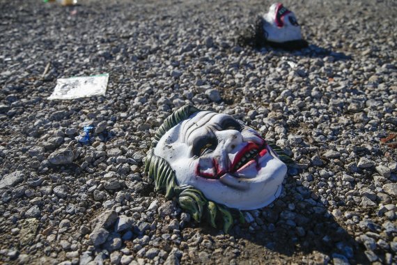 Halloween masks litter the ground amongst signs of chaos at the scene where a mass shooting occurred the night before at Party Venue on Highway 380 in Greenville, Texas, on Sunday, October 27, 2019. As of early Sunday morning a gunman is still at large after killing at least two people and injuring 