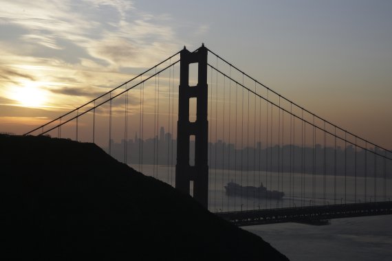 A Matson container ship passes the Golden Gate Bridge Monday, Oct. 28, 2019, in Sausalito, Calif., as smoke from wildfires blankets the San Francisco skyline in the background. A wildfire that has been burning in Northern California's wine country since last week grew overnight as nearly 200,000 peo