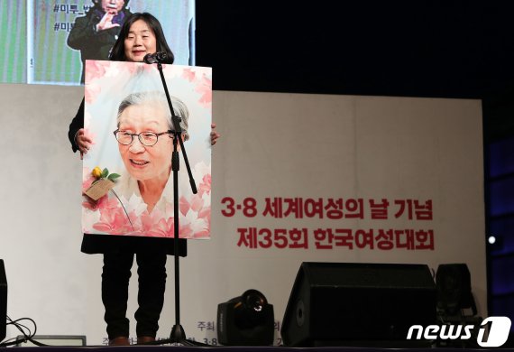 윤미향 정대협 상임대표가 지난 3월 오후 서울 광화문광장에서 열린 3.8세계여성의 날 기념 제35회 한국여성대회에서 여성운동상을 수상한 김복동 할머니의 수상소감을 밝히고 있다. 이번 한국여성대회에서 김복동 할머니는 여성운동상을 서지현 검사는 올해의 여성운동상을 수상했다. 2019.3.8/뉴스1 © News1 박세연 기자