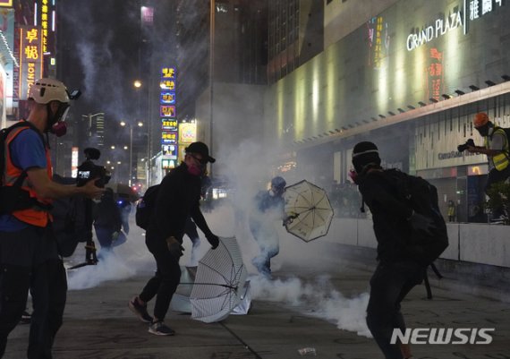 【홍콩=AP/뉴시스】27일(현지시간) 홍콩 민주화를 요구하는 시위에 참가한 홍콩 시민들이 경찰이 발사한 최루탄을 피하고 있다. 이날 홍콩에서는 21번째 주말 시위가 열렸다. 2019.10.28