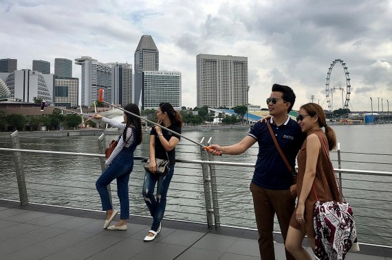 Tourists take pictures in front of the iconic Marina Bay Sands hotelin Singapore, Saturday, Sept. 21, 2019. (AP Photo/Vincent Thian) /뉴시스/AP