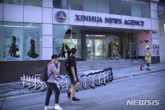 【홍콩=AP/뉴시스】2일 홍콩 도심에서 행인들이 파괴된 신화통신 홍콩사무소 건물 앞을 지나가고 있다. 중국 관영 통신사인 신화통신 건물은 시위대 공격으로 유리창이 부서지는 피해를 입었다. 2019.11.04