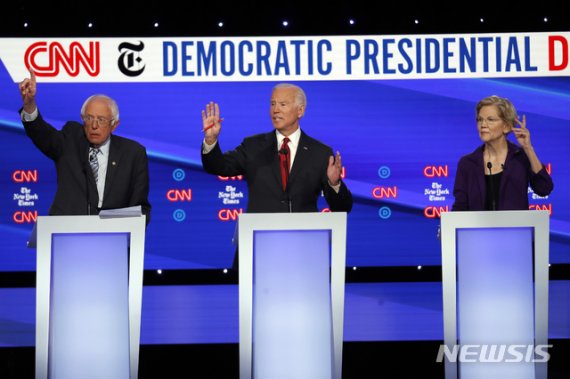 【워싱턴=AP/뉴시스】미국 민주당 주요 대선주자인 버니 샌더스(맨 왼쪽) 민주당 상원의원과 조 바이든 전 부통령(가운데), 엘리자베스 워런 상원의원이 15일(현지시간) CNN과 뉴욕타임스(NYT)가 주최한 후보토론에서 발언을 위해 손을 들고 있다. 2019.10.16.