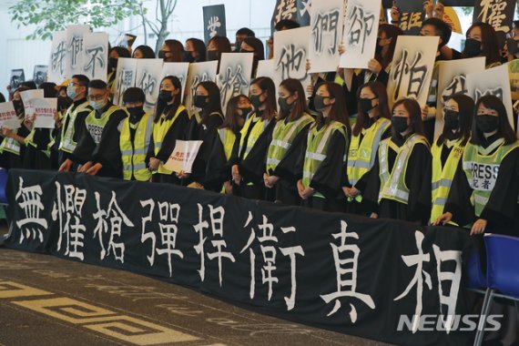 【 홍콩=AP/뉴시스】마스크를 쓴 홍콩 중문대 졸업생들이 7일 졸업식 도중 "탄환은 무섭지 않다"는 구호가 적힌 플래카드를 걸어놓고 기습시위를 벌이고 있다. 2019.11.07
