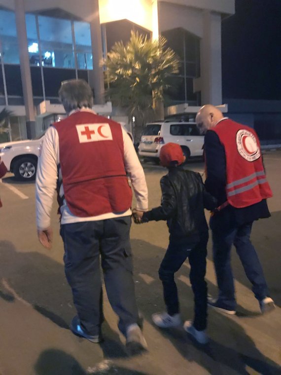 지난 6일(현지시간) 시리아 다마스쿠스에서 알바니아 출신의 11세 소년이 현지 적신월 및 적십자 요원들의 손을 잡고 공항으로 향하고 있다. 그는 어머니의 손에 이끌려 이슬람국가(IS)에 합류했다가 어머니와 형제자매들이 사망한 뒤 홀로 시리아 북부의 쿠르드족 수용소에 머물렀다. 국제사회의 도움으로 풀려난 소년은 아버지가 있는 이탈리아로 향하게 됐다.AP뉴시스