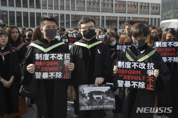 【 홍콩=AP/뉴시스】홍콩 중문대 졸업생들이 7일 졸업식 도중 검은 마스크를 쓰고 플래카드를 든채 시위를 벌이고 있다. 2019.11.07