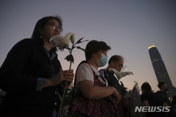 【홍콩=AP/뉴시스】9일 오후 홍콩 도심에서 시민들이 생화를 들고 경찰이 쏜 최루탄을 피하려다 추락해 사망한 홍콩과학기술대 22세 대학생을 추모하고 있다. 2019.11.10