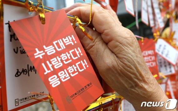 2020학년도 수능시험을 앞두고 지난 10일 서울 종로구 조계사에서 한 할머니가 손자의 학업 성취를 기원하는 문구가 적힌 소원지를 새끼줄에 매달고 있다. © News1 이동해 기자