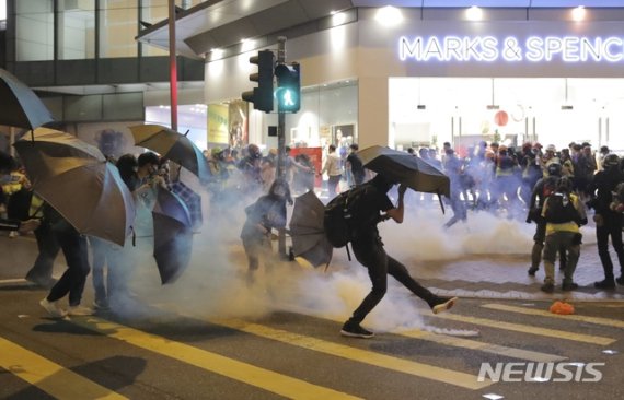 【홍콩=AP/뉴시스】 10일 밤 홍콩 민주화 시위대가 경찰의 최루탄을 우산으로 막고 있다. 이날 시위대는 지하철역의 매표기기를 파손하고 친(親)중국 성향의 식당 및 상점의 유리창을 깨는 등 강한 저항에 나섰다. 2019.11.11.