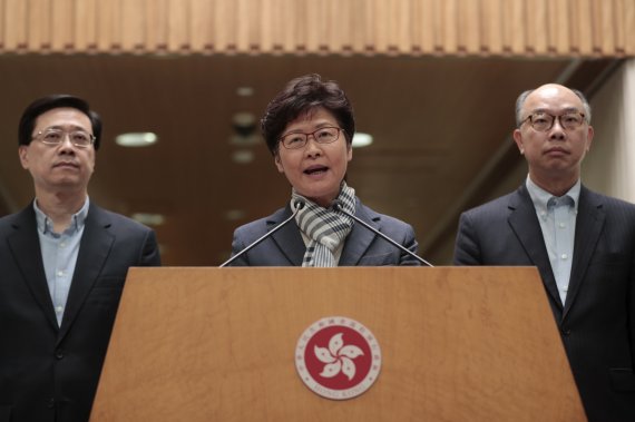 Hong Kong Chief Executive Carrie Lam, center, speaks during a press conference in Hong Kong, Monday, Nov. 11, 2019. A protester was shot by police Monday in a dramatic scene caught on video as demonstrators blocked train lines and roads in a day of spiraling violence fueled by demands for democratic