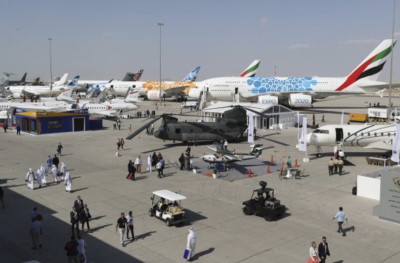 People visit planes during the opening day of the Dubai Airshow, in Dubai, United Arab Emirates, Sunday, Nov. 17, 2019. The biennial airshow opened as major Gulf airlines reign back big-ticket purchases after a staggering $140 billion in new orders were announced at the 2013 show before global oil p