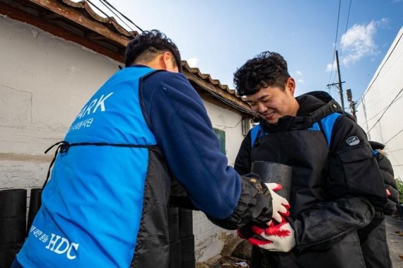 HDC현대산업개발 직원들이 지난 19일 서울 용산구 한강로동 일대에서 연탄을 나르고 있다.