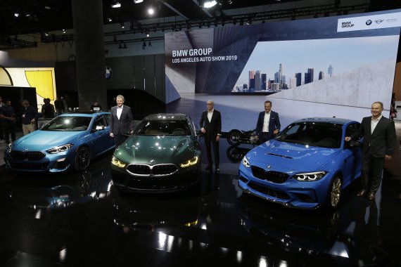 The BMW Group executives pose with new vehicles during AutoMobility LA at the Los Angeles Auto Show in Los Angeles, Wednesday, Nov. 20, 2019. From left, BMW 2 Series Gran Coupe, 2019 BMW M8 Gran Coupe and BMW M2 CS vehicles. (AP Photo/Damian Dovarganes) /뉴시스/AP /사진=