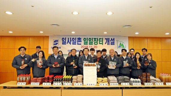 지난 20일 신동아건설 본사 대강당에서 열린 직거래장터 행사에 참여한 이인찬 대표이사(가운데)와 임직원들이 덕전마을 주민들과 함께 기념촬영을 하고 있다. 신동아건설 제공