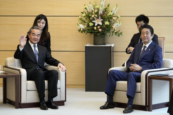 지난 달 25일 아베 신조 일본 총리가 중국 왕이 외교부장을 접견하고 있다. AP뉴시스